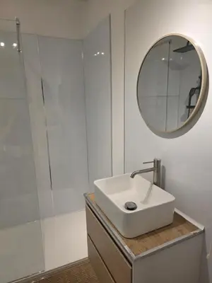 a white bathroom with a sink and a mirror at Studio hypercentre in Castelnaudary