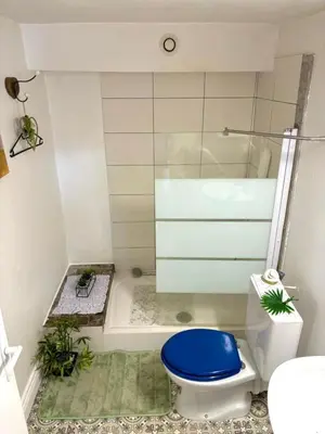 a bathroom with a blue toilet and a shower at Studio équipé in Narbonne