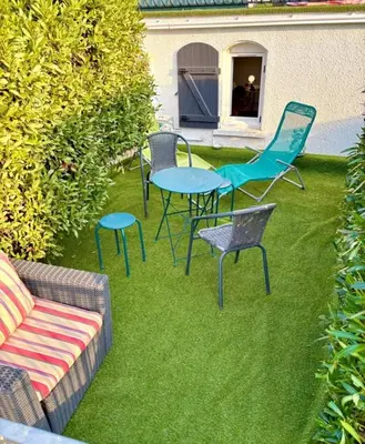 a group of chairs and a table and chairs on the grass at Studio équipé in Narbonne