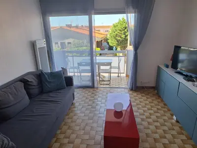 a living room with a couch and a television at Bel appartement proche de la mer in Port-la-Nouvelle