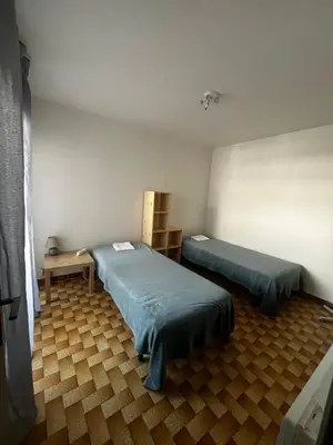 a room with two beds and a table in it at Bel appartement proche de la mer in Port-la-Nouvelle