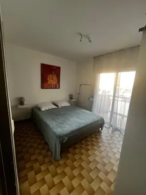 a bedroom with a bed and a large window at Bel appartement proche de la mer in Port-la-Nouvelle