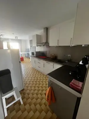 a kitchen with white cabinets and a black counter top at Bel appartement proche de la mer in Port-la-Nouvelle