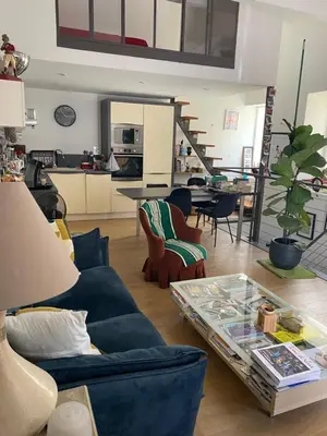 a living room with a blue couch and a table at Maison bougainvillier Gruissan Village in Gruissan