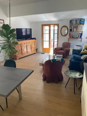 a living room with a blue couch and a tv at Maison bougainvillier Gruissan Village in Gruissan