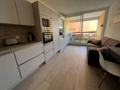 a kitchen with a couch and a table in a room at Gruissan appartement Haut Standing in Gruissan