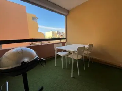 a room with a table and chairs and a large window at Gruissan appartement Haut Standing in Gruissan