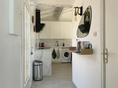 a white kitchen with a sink and a washing machine at La Pause Nouvelle - CLIM - 5 min de la plage in Port-la-Nouvelle
