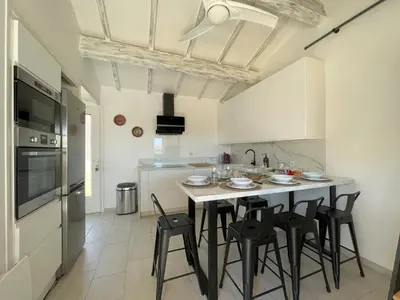 a kitchen with a table and chairs in a room at La Pause Nouvelle - CLIM - 5 min de la plage in Port-la-Nouvelle