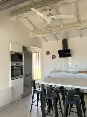 a kitchen with a large white table and chairs at La Pause Nouvelle - CLIM - 5 min de la plage in Port-la-Nouvelle