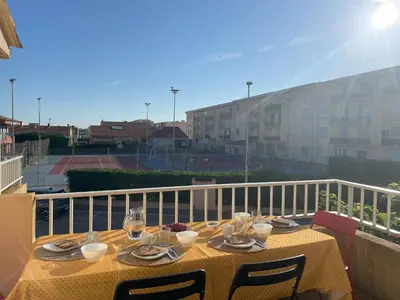 a table with a yellow table cloth on a balcony at La Pause Nouvelle - CLIM - 5 min de la plage in Port-la-Nouvelle