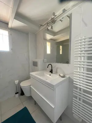 a white bathroom with a sink and a toilet at La Pause Nouvelle - CLIM - 5 min de la plage in Port-la-Nouvelle