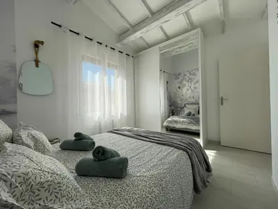 a white bedroom with two towels on a bed at La Pause Nouvelle - CLIM - 5 min de la plage in Port-la-Nouvelle