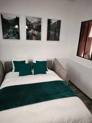 a bedroom with a large white bed with green pillows at Chez Mel et Garry in Villedaigne
