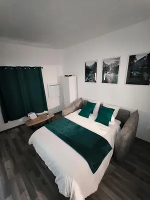 a bedroom with a large white bed with green pillows at Chez Mel et Garry in Villedaigne