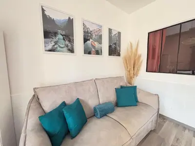 a couch with three blue pillows in a living room at Chez Mel et Garry in Villedaigne