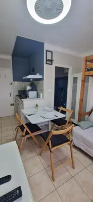 a kitchen with a table and chairs in a room at Studio rénové à 70m de la plage in Port-la-Nouvelle