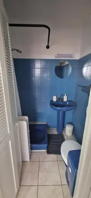 a blue tiled bathroom with a toilet and a sink at Studio rénové à 70m de la plage in Port-la-Nouvelle