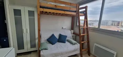 a bedroom with a bunk bed and a ladder at Studio rénové à 70m de la plage in Port-la-Nouvelle
