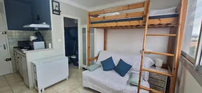 a small room with a bunk bed and a couch at Studio rénové à 70m de la plage in Port-la-Nouvelle