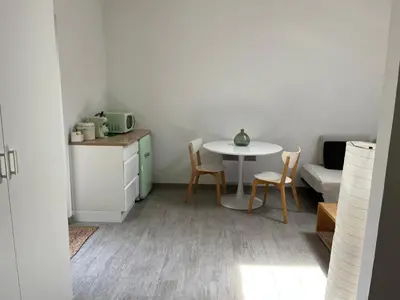 a kitchen with a table and a table and chairs at Chambre À la croisée des sens in Carcassonne