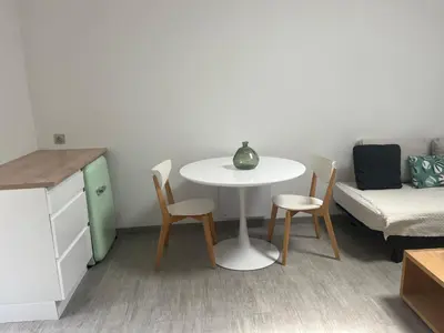 a small room with a table and chairs and a bed at Chambre À la croisée des sens in Carcassonne