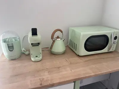 a microwave and other appliances sitting on a table at Chambre À la croisée des sens in Carcassonne