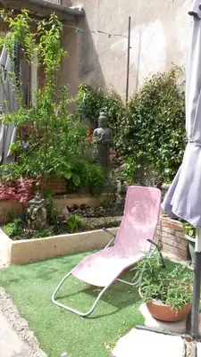 a pink chair sitting on the grass in a garden at Chambre d hôtes Cap instant in Capestang