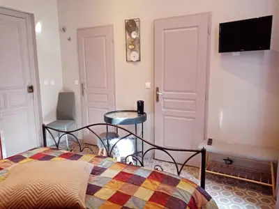 a bedroom with a bed and a tv on the wall at Chambre d hôtes Cap instant in Capestang