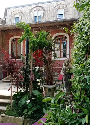 a garden in front of a brick building at Chambre d hôtes Cap instant in Capestang
