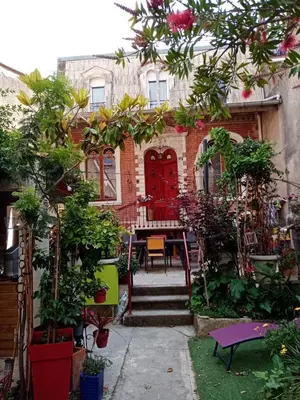 a house with a red door and some trees at Chambre d hôtes Cap instant in Capestang