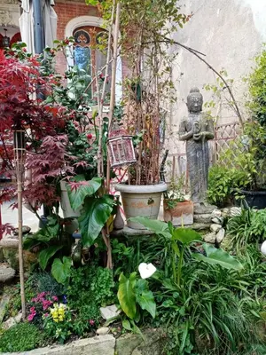 a garden with a statue and some plants at Chambre d hôtes Cap instant in Capestang