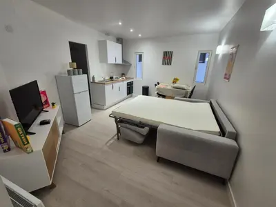 a small room with a bed and a kitchen at Lylo in Carcassonne