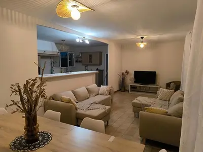 a living room with couches and a table and a kitchen at Maison calme avec piscine in Montredon