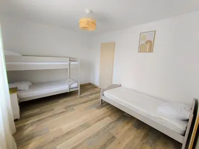 a room with two bunk beds and a wooden floor at Maison calme avec piscine in Montredon