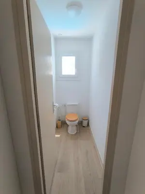 a small bathroom with a toilet with a wooden floor at Maison calme avec piscine in Montredon