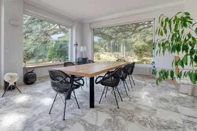 a dining room with a wooden table and black chairs at Villa Corbière - Piscine Privée in Castres