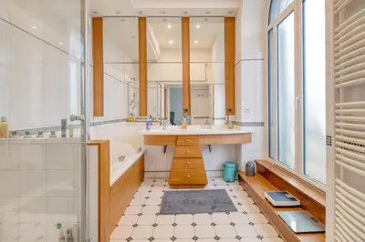 a bathroom with a sink and a tub and a mirror at Villa Corbière - Piscine Privée in Castres