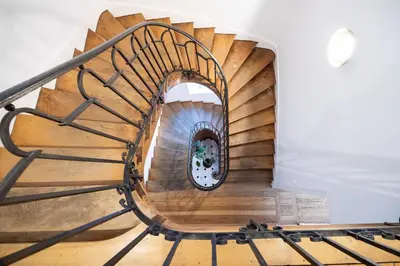a spiral staircase in a house with wooden floors at Villa Corbière - Piscine Privée in Castres
