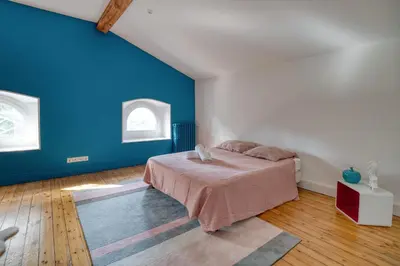 a bedroom with a bed and a blue wall at Villa Corbière - Piscine Privée in Castres