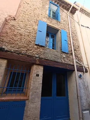 a building with blue doors and windows at Maison entière Les Maisons de Gaia in Tuchan