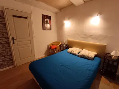 a bedroom with a blue bed in a room at Maison entière Les Maisons de Gaia in Tuchan
