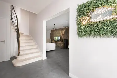 a hallway with a staircase and a green wall at Villa à Castres, Maison 10 personnes avec piscine privée, jardin et 5 chambres in Castres