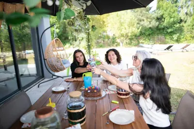 a group of women sitting around a table with a cake at Villa à Castres, Maison 10 personnes avec piscine privée, jardin et 5 chambres in Castres