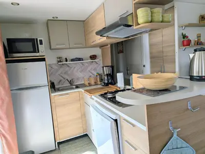 a bedroom with a bed with a blue comforter at Mobil home 6 à 8 personnes climatisé in Saint-Papoul