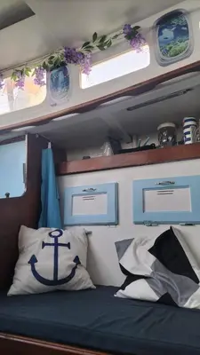 a bedroom with a bed with an anchor pillow and windows at AMADONNe in Gruissan