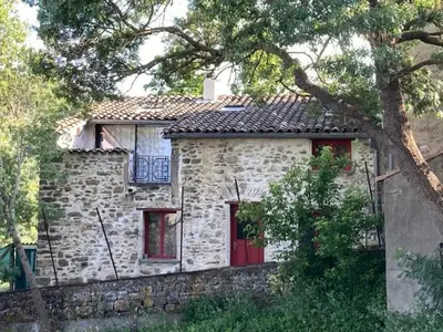 a stone house with red doors and a stone wall at Jolie maison vintage, à 15mn de Lagrasse in Taurize