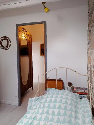a bedroom with a bed and a mirror at Jolie maison vintage, à 15mn de Lagrasse in Taurize