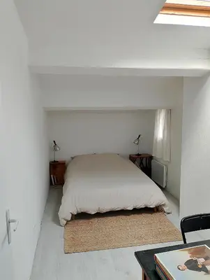 a white bedroom with a bed and a table at Jolie maison vintage, à 15mn de Lagrasse in Taurize