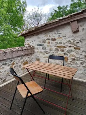 a wooden picnic table and two chairs on a deck at Jolie maison vintage, à 15mn de Lagrasse in Taurize